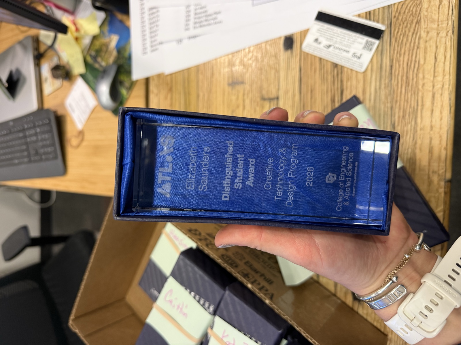 The ATLAS Institute Distinguished Student Award, a glass trophy engraved with Elizabeth Saunders' name